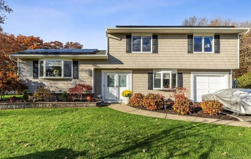 Split-level home with fall foliage in Bohemia, New York, purchased by buyers Thomas Brady represented