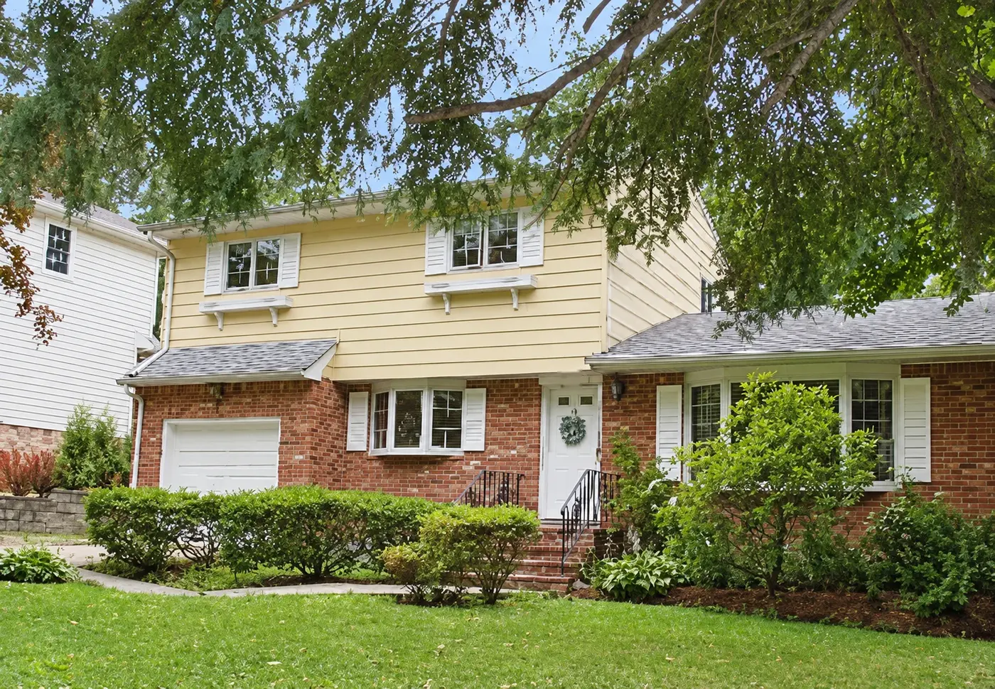 Two-story brick and yellow-sided home in Hauppauge, New York, listed and sold by Thomas Brady